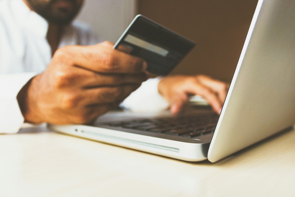 Kleinunternehmer bezahlt am Laptop mit Karte
